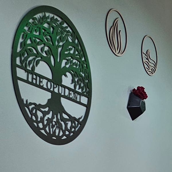 Green tree of life wall art with "THE OPULENT" text, alongside smaller decorative pieces and a red rose.