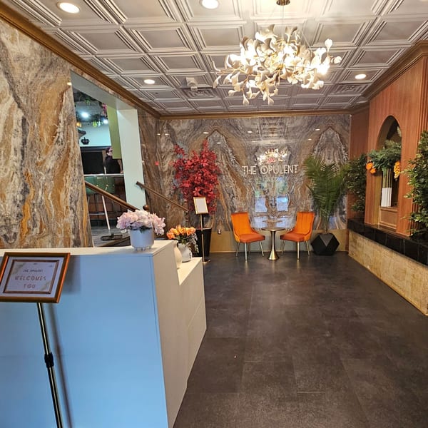 The Opulent Restaurant and Lounge's elegant lobby with a welcome desk, seating, and ornate decor.