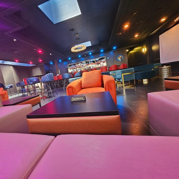 The Opulent Restaurant and Lounge's vibrant interior with orange, blue, and pink seating, and a bar.